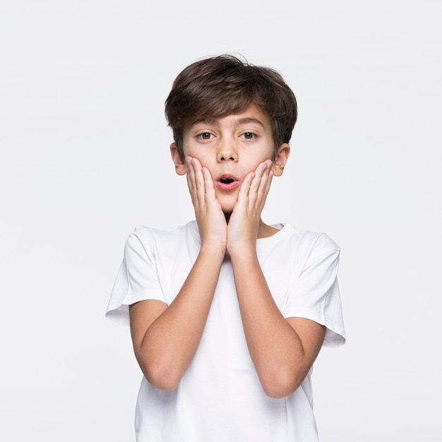 Young boy on white background surprised