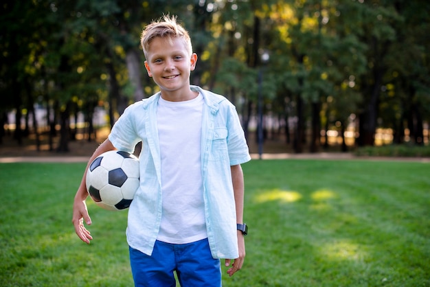 Young boy with football ball looking at camera