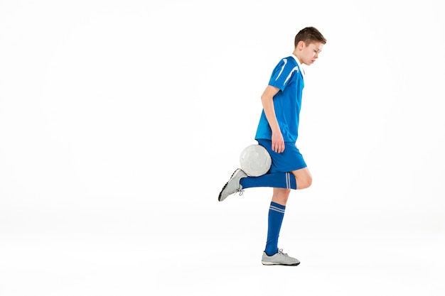 Young boy with soccer ball doing flying kick