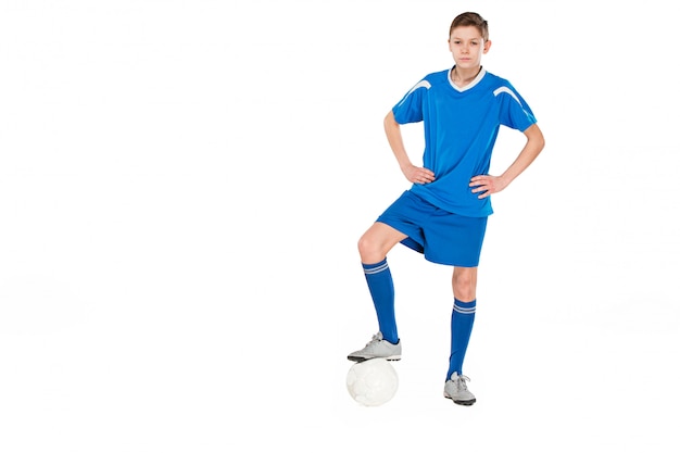 Free photo young boy with soccer ball doing flying kick