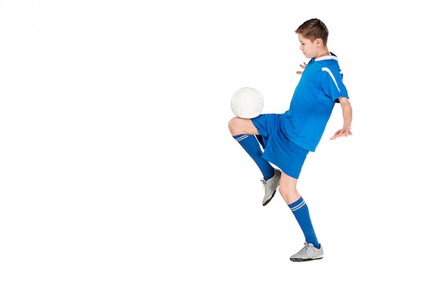 Young boy with soccer ball doing flying kick