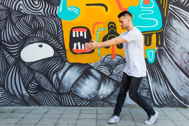 Free photo young breakdancer dancing against painted textured