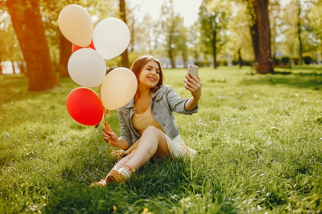 Free photo young and bright girls walking in the summer park with balloons