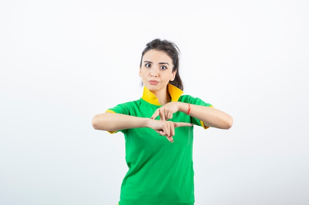 Young brunette girl in green t-shirt standing and looking. 