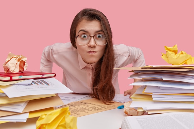 Free photo young brunette student sitting at desk with books