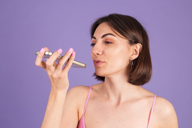 Free photo young brunette in top isolated on purple wall