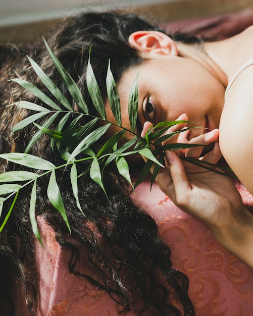 Young brunette with leaves looking at camera