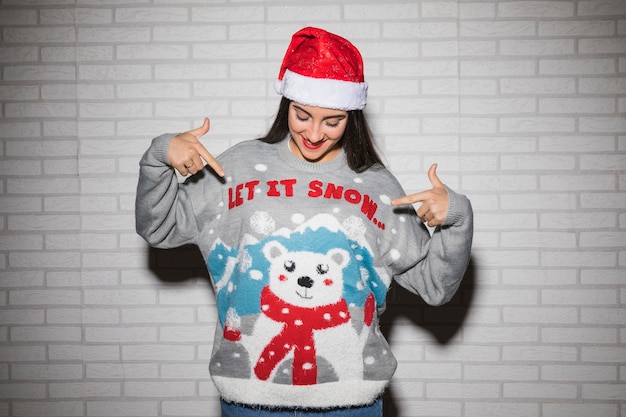 Free Photo young brunette woman in christmas hat and sweater 