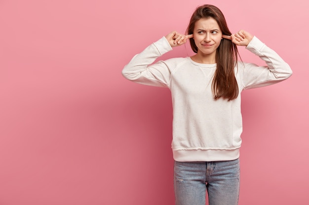 Free photo young brunette woman in jeans and sweater