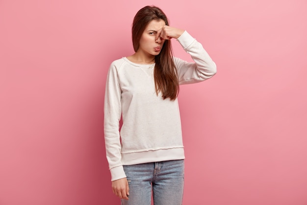 Free photo young brunette woman in jeans and sweater