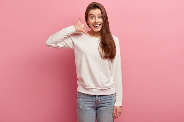 Free photo young brunette woman in jeans and sweater