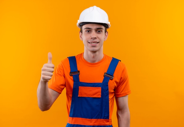 Young builder man wearing construction uniform and safety helmet doing happy thumbs up