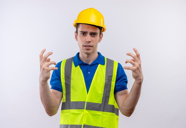 Free photo young builder man wearing construction uniform and safety helmet fed up