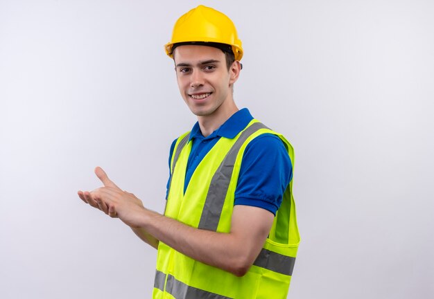 Young builder man wearing construction uniform and safety helmet happy applauds