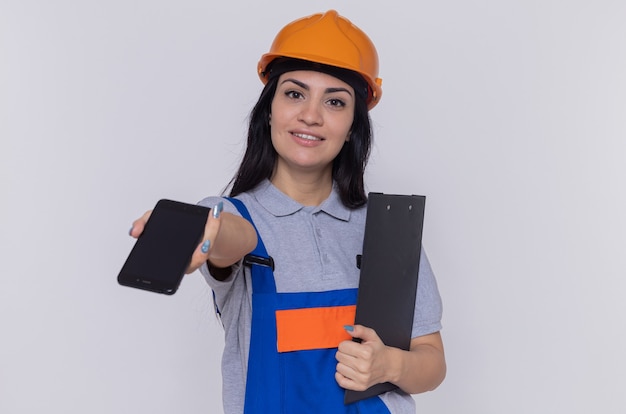 Young builder woman in construction uniform and safety helmet