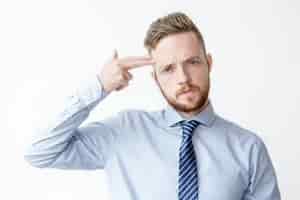 Free photo young business man shooting himself with fingers