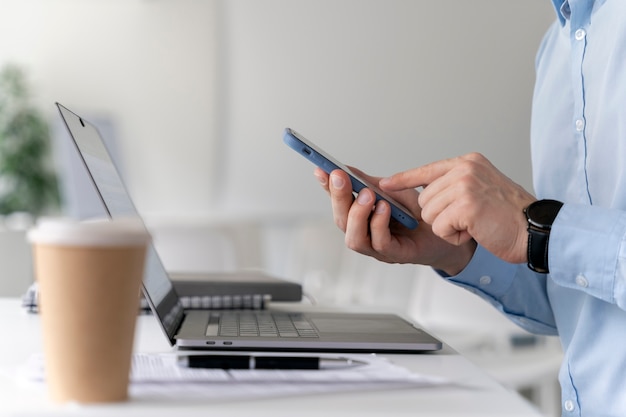 Free Photo young business man working at her desk with laptop and smartphone