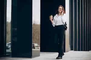 Free photo young business woman drinking coffee by the business center