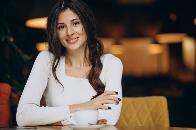 Young business woman drinking coffee in a cafe