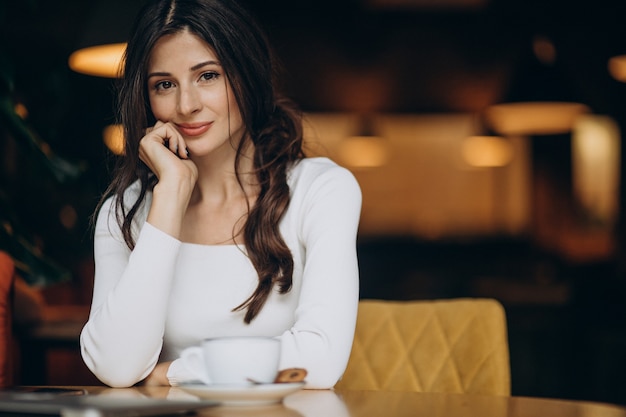 Young business woman drinking coffee in a cafe