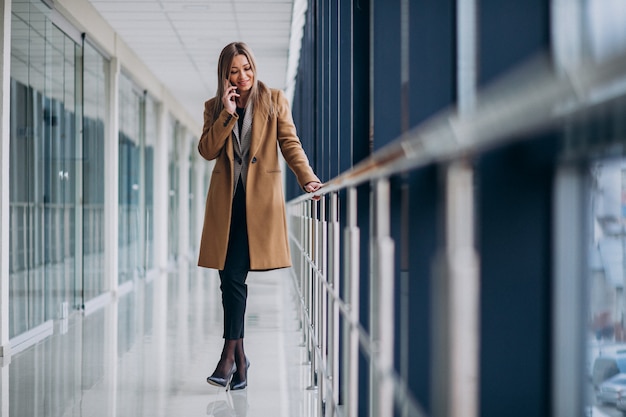 Free photo young business woman talking on the phone in an airport