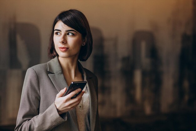 Young business woman using phone in a cafe