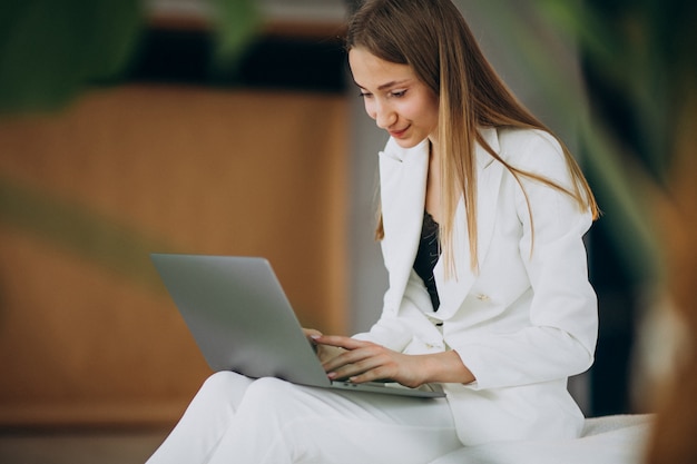 Free photo young business woman in white suit working on a computer