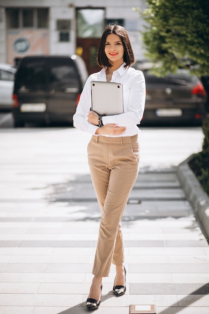 Free Photo young business woman with laptop outside the street