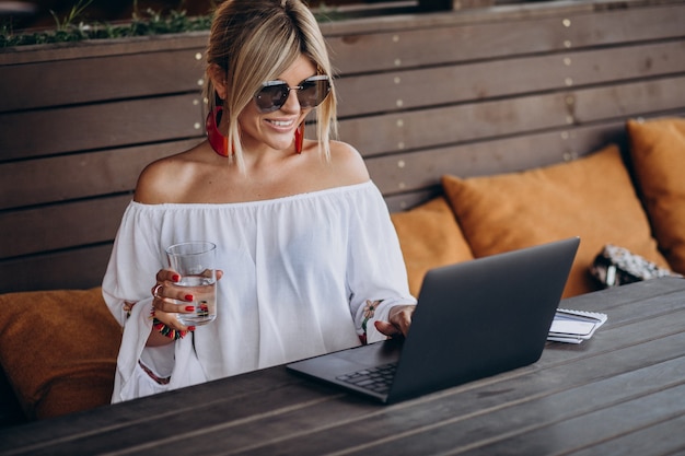 Free photo young business woman working on computer in bar