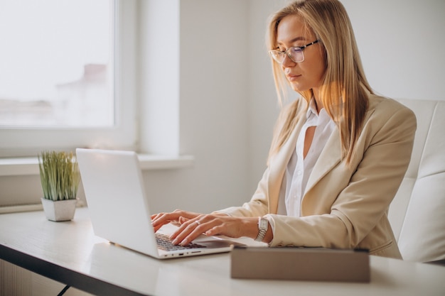 Free photo young business woman working on computer in office