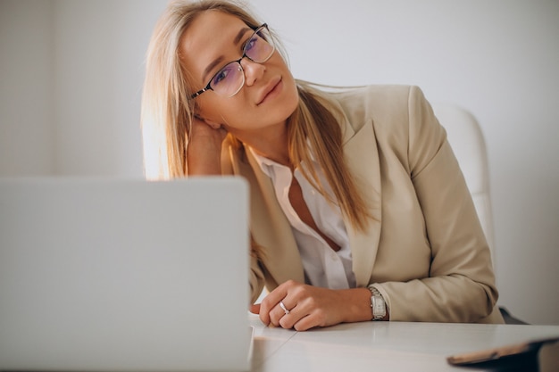 Free photo young business woman working on computer in office