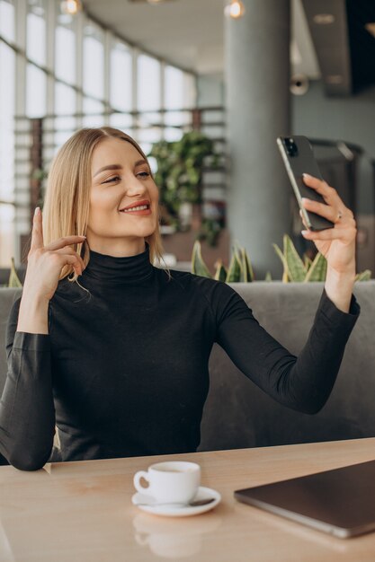 Young business woman working on laptop in a cafe