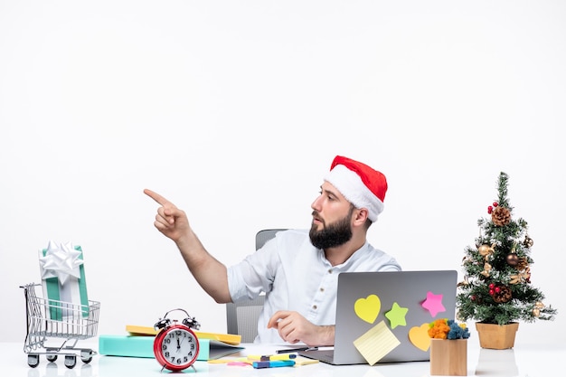 Young businessman in office celebrating christmas working alone pointing something