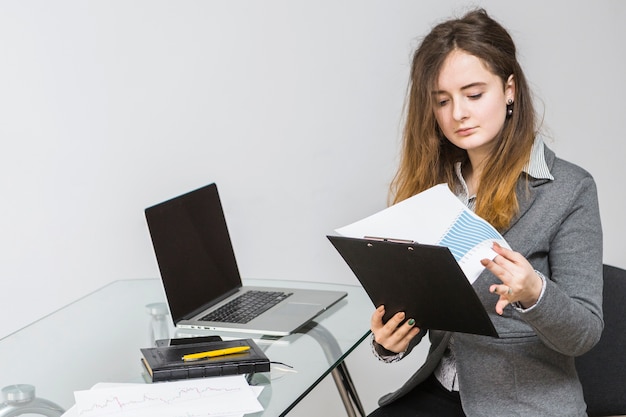 Free photo young businesswoman analyzing graph