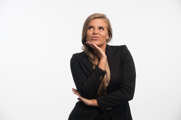 Young businesswoman in black suit looks happy and confident. 