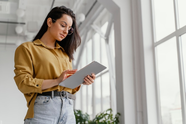 Young businesswoman checking her tablet with copy space