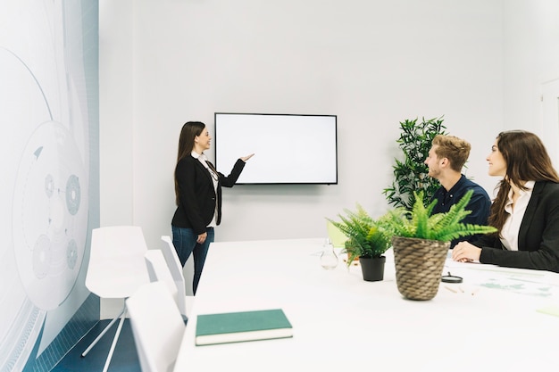 Young businesswoman giving presentation in office