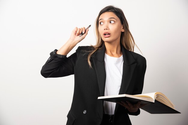 Young businesswoman holding an opened clipboard with pencil .