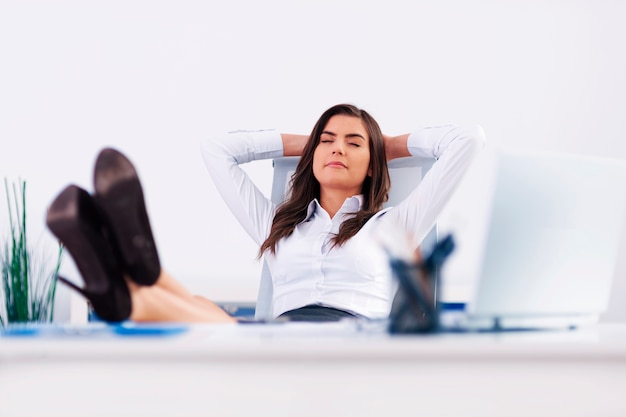 Free photo young businesswoman relaxing in office