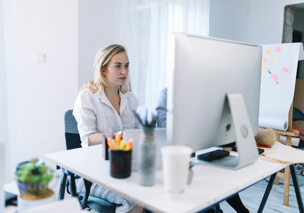 Free photo young businesswoman working on computer in office