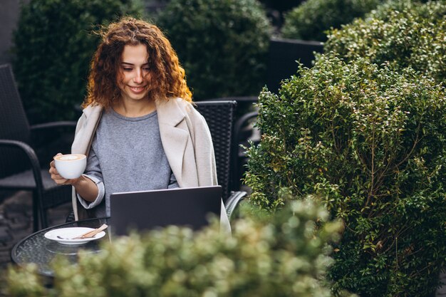 Young businesswoman working on a computer outside the cafe