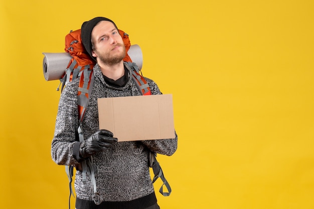 young camper with leather gloves and backpack holding blank cardboard