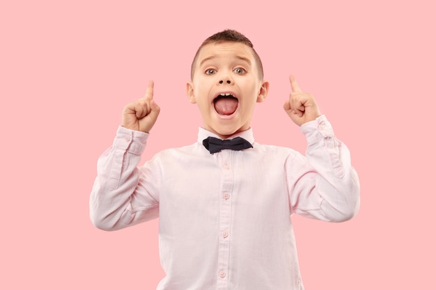 Young casual boy shouting. Shout. Crying emotional teen screaming on pink studio background. The male half-length portrait.