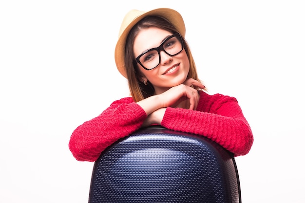 Young casual woman standing with travel suitcase - isolated on white wall. Vocation concept