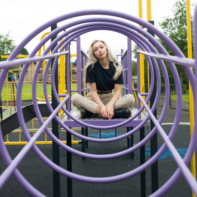 Young Caucasian female sitting in circled climb in the playground