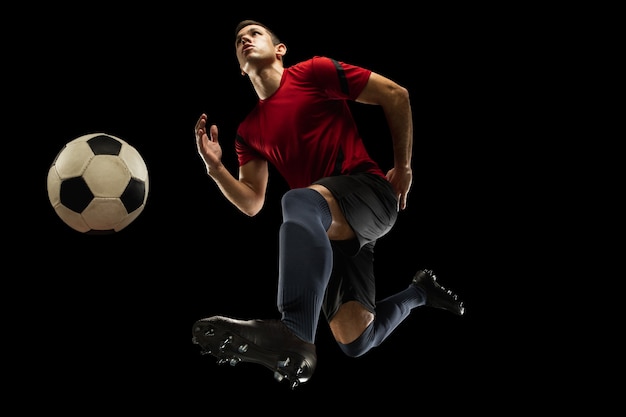 Free photo young caucasian football, soccer player in action, motion isolated on black background