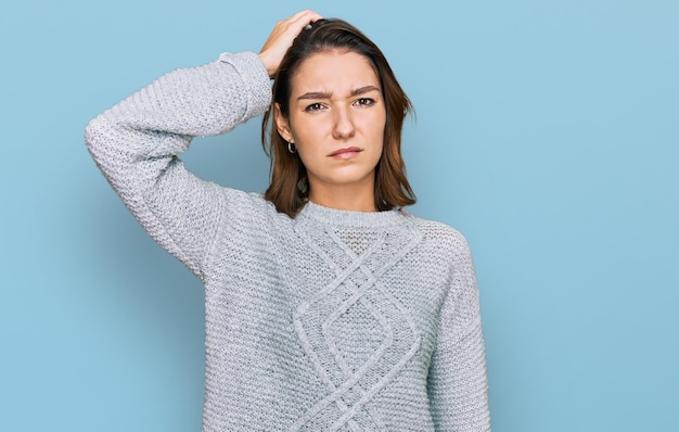 Young caucasian girl wearing casual clothes confuse and wonder about question uncertain with doubt thinking with hand on head pensive concept