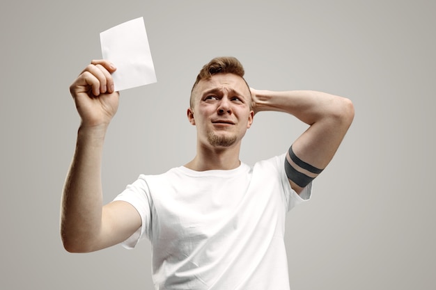 Young caucasian man with a surprised happy expression won a bet on gray  space