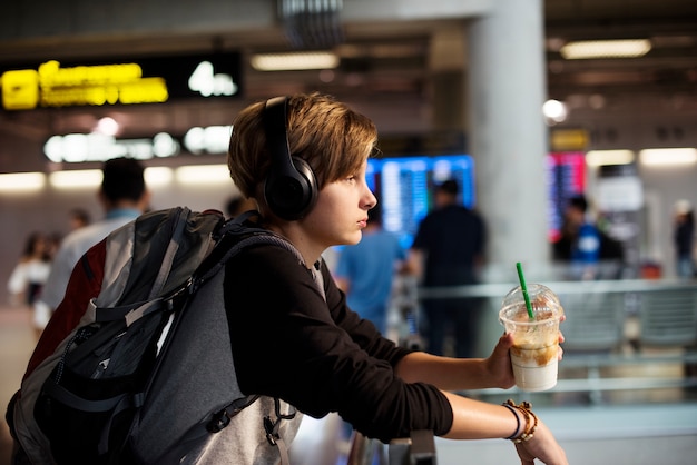 Free photo young caucasian traveler holding drink beverage in the airport