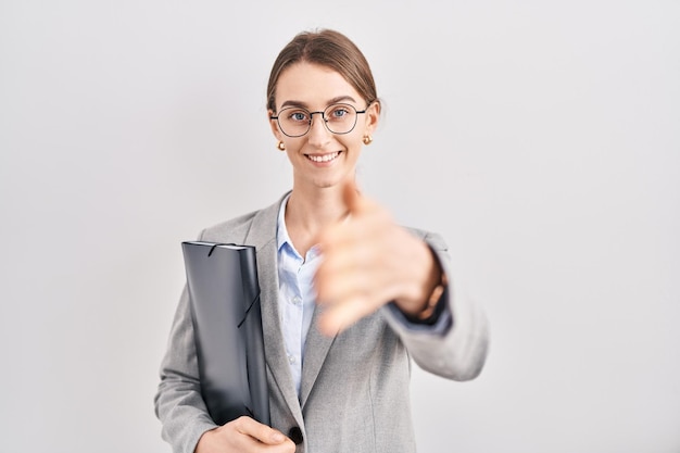 Free photo young caucasian woman wearing business clothes and glasses smiling friendly offering handshake as greeting and welcoming. successful business.